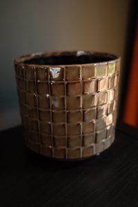 Sage green ceramic planter with a glossy glaze and raised grid texture, measuring 15cm high and 16cm wide, shown against a plain background